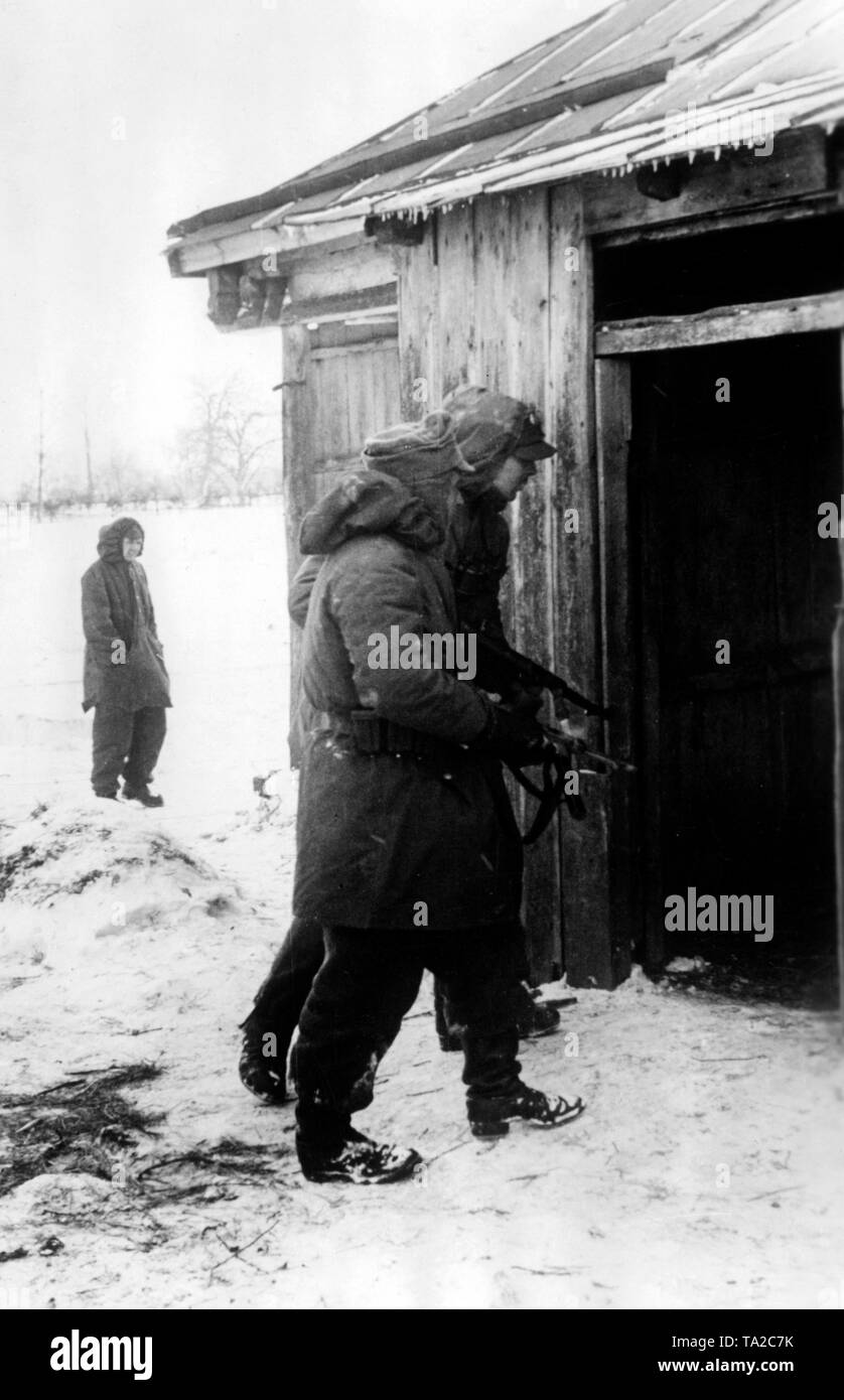 German soldiers search a village southwest of Kharkov with a ready to fire gatling gun (MP 40). Photo of the Propaganda Company (PK): Augustin. Stock Photo