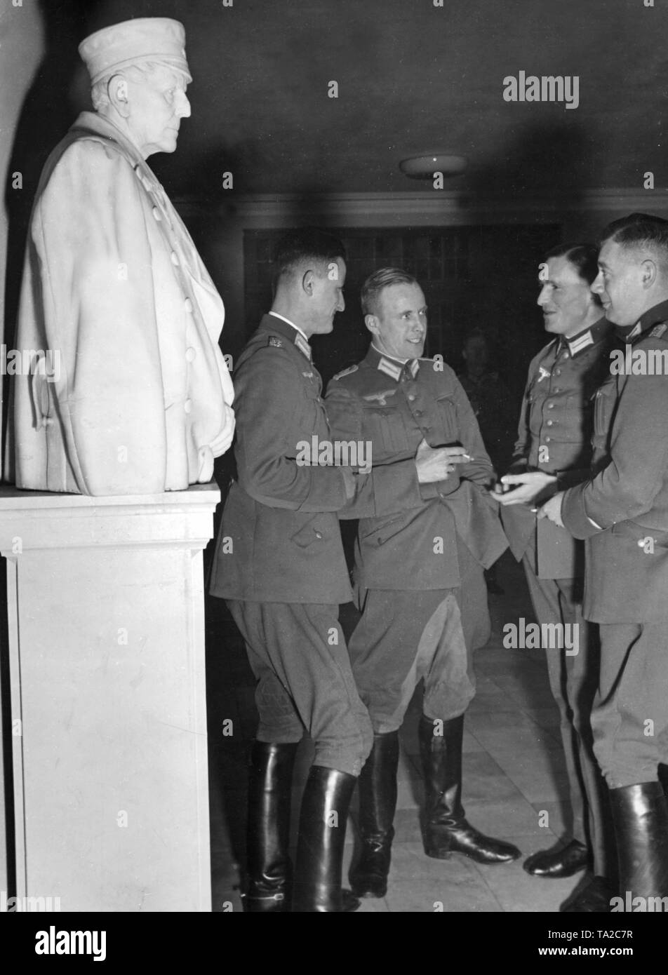 Wehrmacht officers talk in front of a marble bust of the chief of staff of the Prussian Army Hemut v. Moltke. The men take part in a course at the Berlin War Academy. Stock Photo