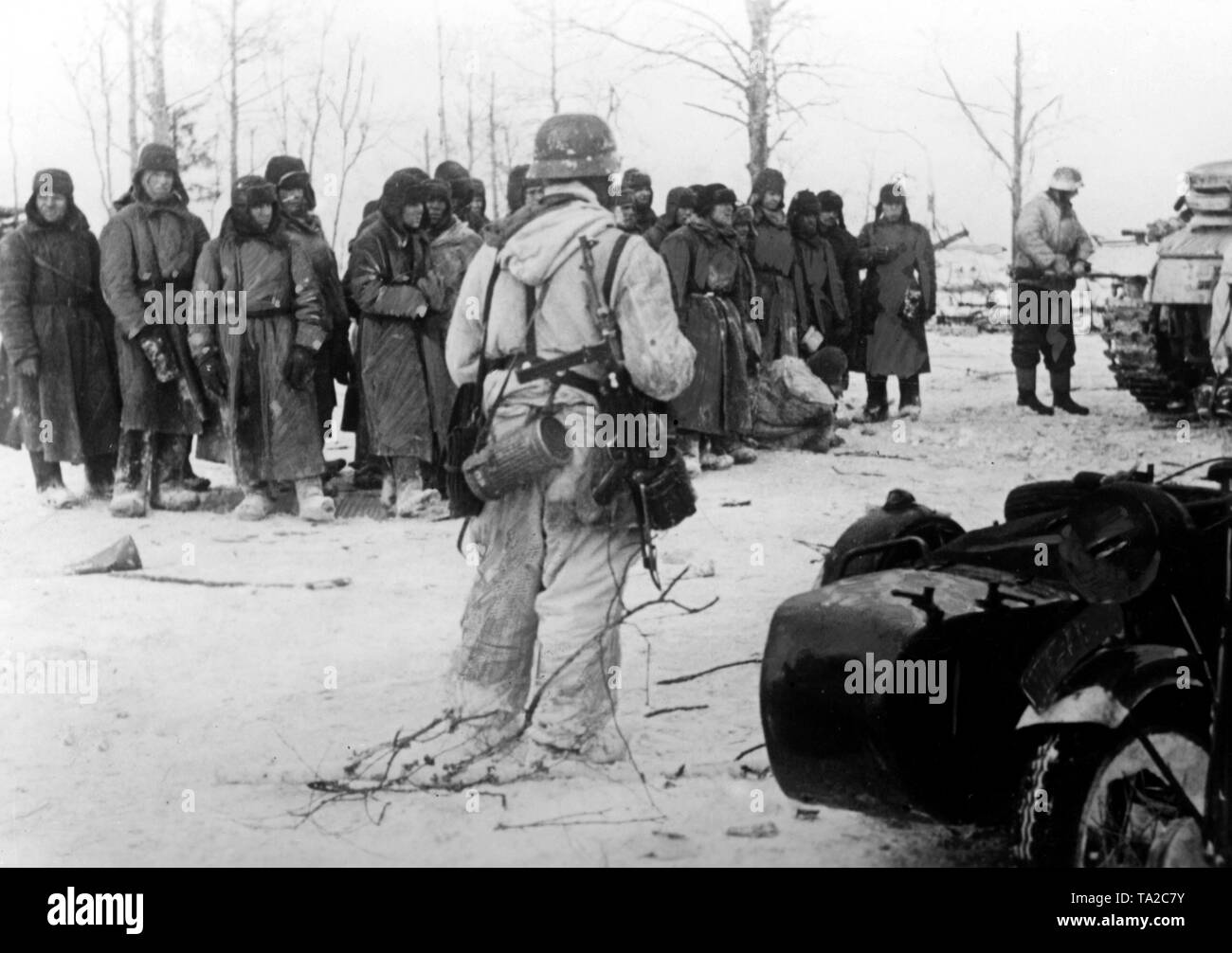 A group of Soviet prisoners of war are standing in a field south of ...