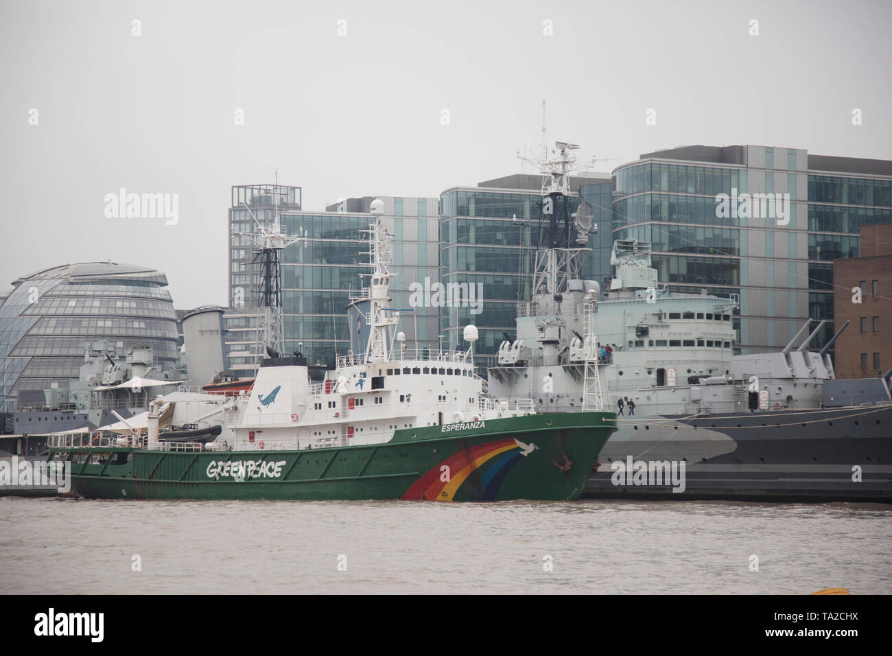 Greenpeace ship Esperanza docked alongside HMS Belfast on the River Thames in London, United Kingdom. Greenpeace is a non-governmental environmental organization with offices in over 39 countries. Stock Photo