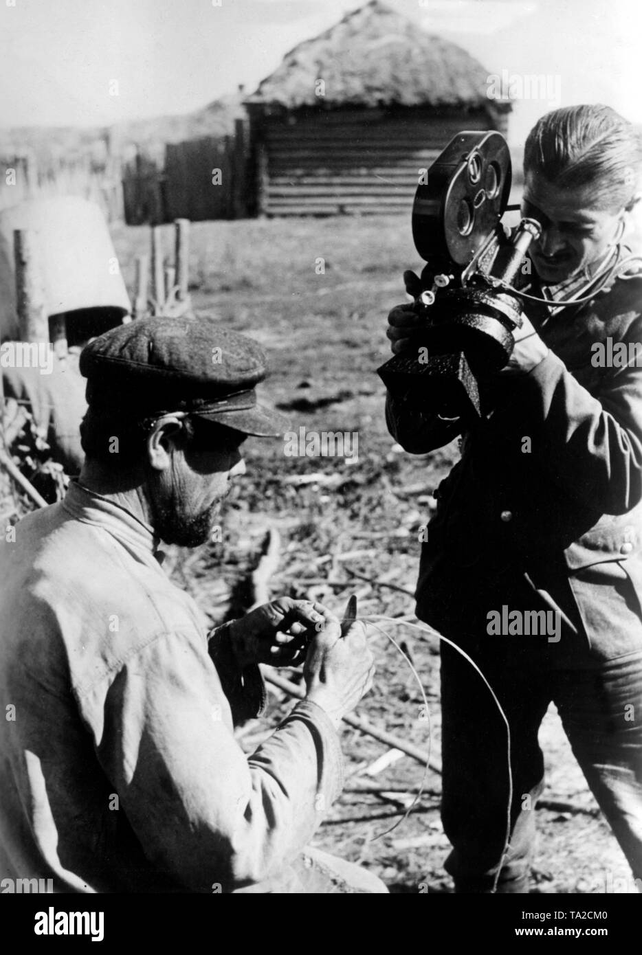 German war correspondent films Soviet peasants during the production of traditional opanaks. The photo was supposed to illustrate the scarcity of raw materials of the Soviet people. Photo: war correspondent Goehring Stock Photo