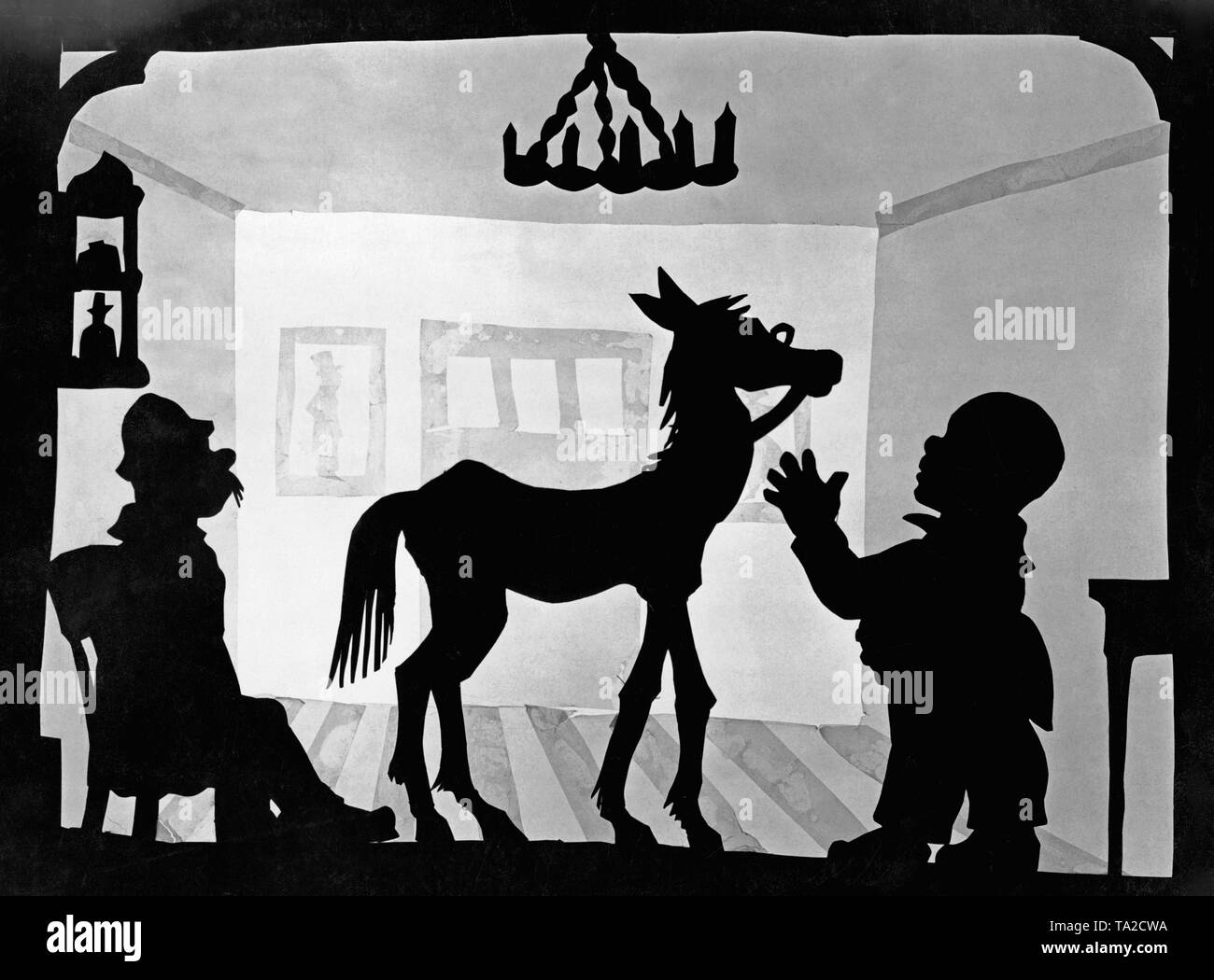 This photo shows a scene from the silhouette film 'Dr. Dolittle and His Animals' - subtitle: 'Das kranke Pferd' by Charlotte Reiniger. The silhouette film, also known as silhouette animation, is a technique of animated film in which silhouettes are put together on a lighted glass plate in front of a white or black background to form a film. The result is the silhouette film, inspired by shadow theater and the pictorial techniques of silhouette cutting. Stock Photo