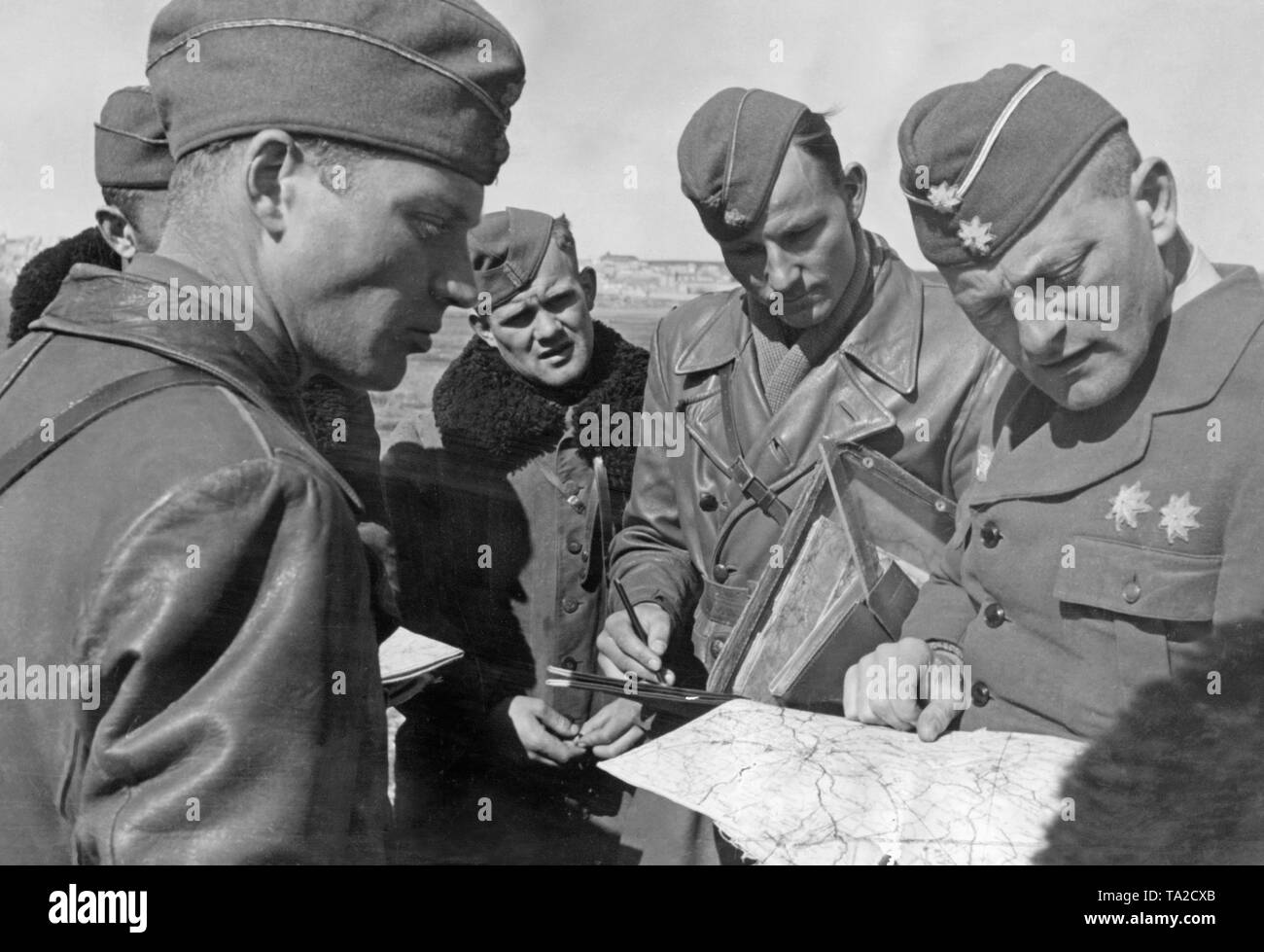 Undated photo of a briefing of combat pilots of the Condor Legion during the Spanish Civil War in 1939. A Major (right) shows the pilots their operational areas on a map. Stock Photo