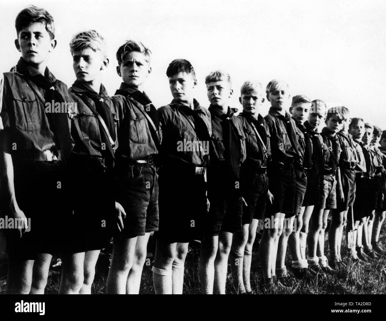 The first members of the Deutsches Jungvolk are standing in line in 1933. They are wearing their new uniforms: brown shirts, black truncheons and the lightning symbol on the belt buckle. Stock Photo