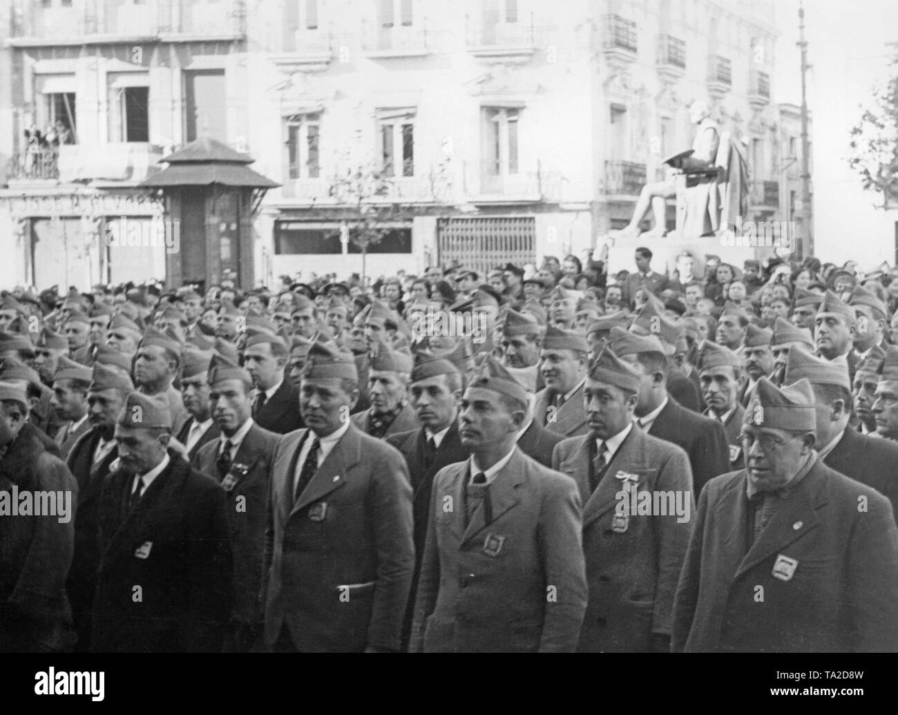 Photo of militants of the Falange Espanola (Fascist Party of Spain) in an unknown city ??of Spain invaded by General Franco's troops six months after the outbreak of the Civil War. The attendants stand upright and pledge their faithfulness to the Spanish national government. They wear gorillo caps and civilian clothes ornamented with stickers of the party (yoke and arrows). Stock Photo
