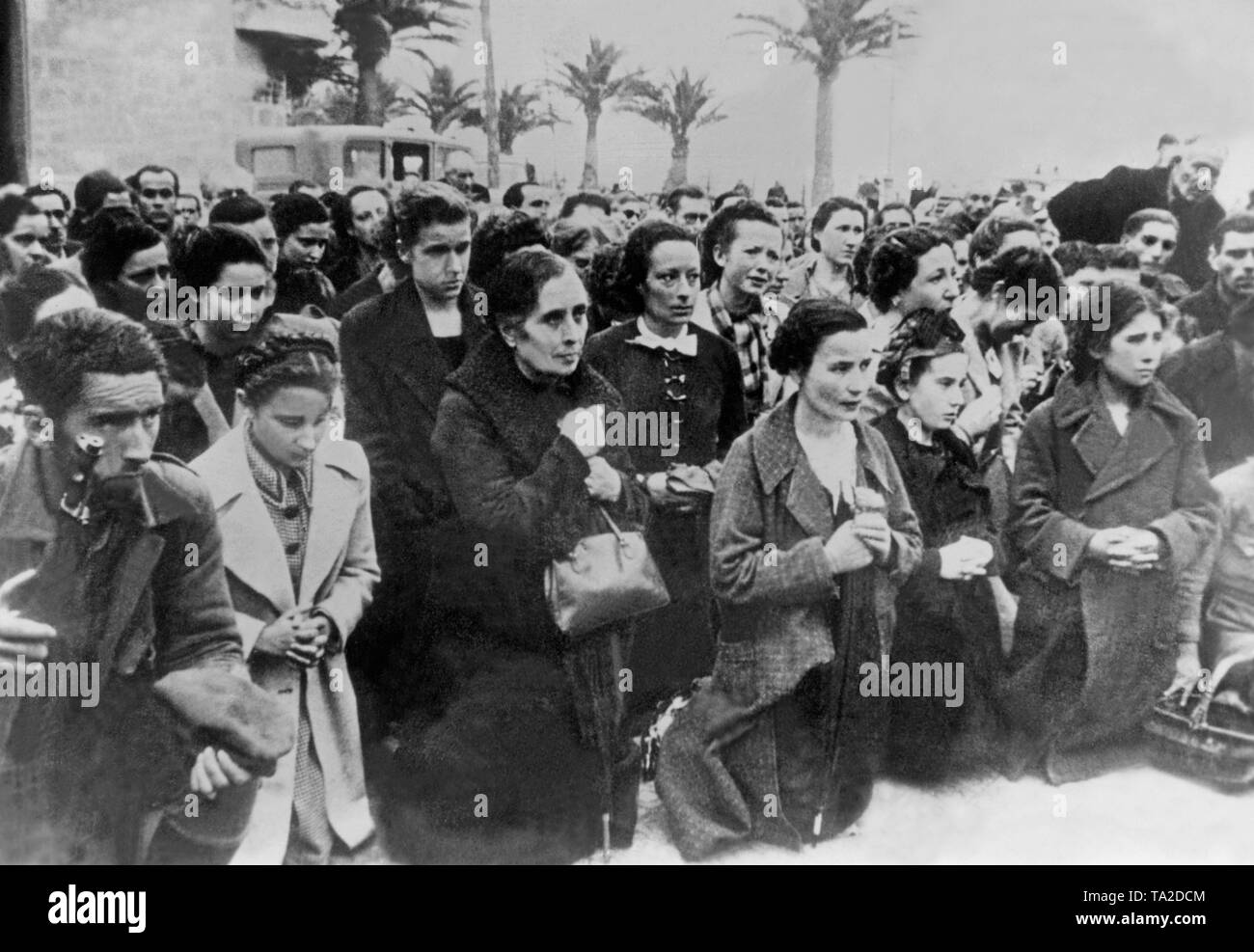 Followers of Franco (women and men) kneel during a church service after entry of the troops in the Catalan Tarragona on 27 January 1939. Stock Photo