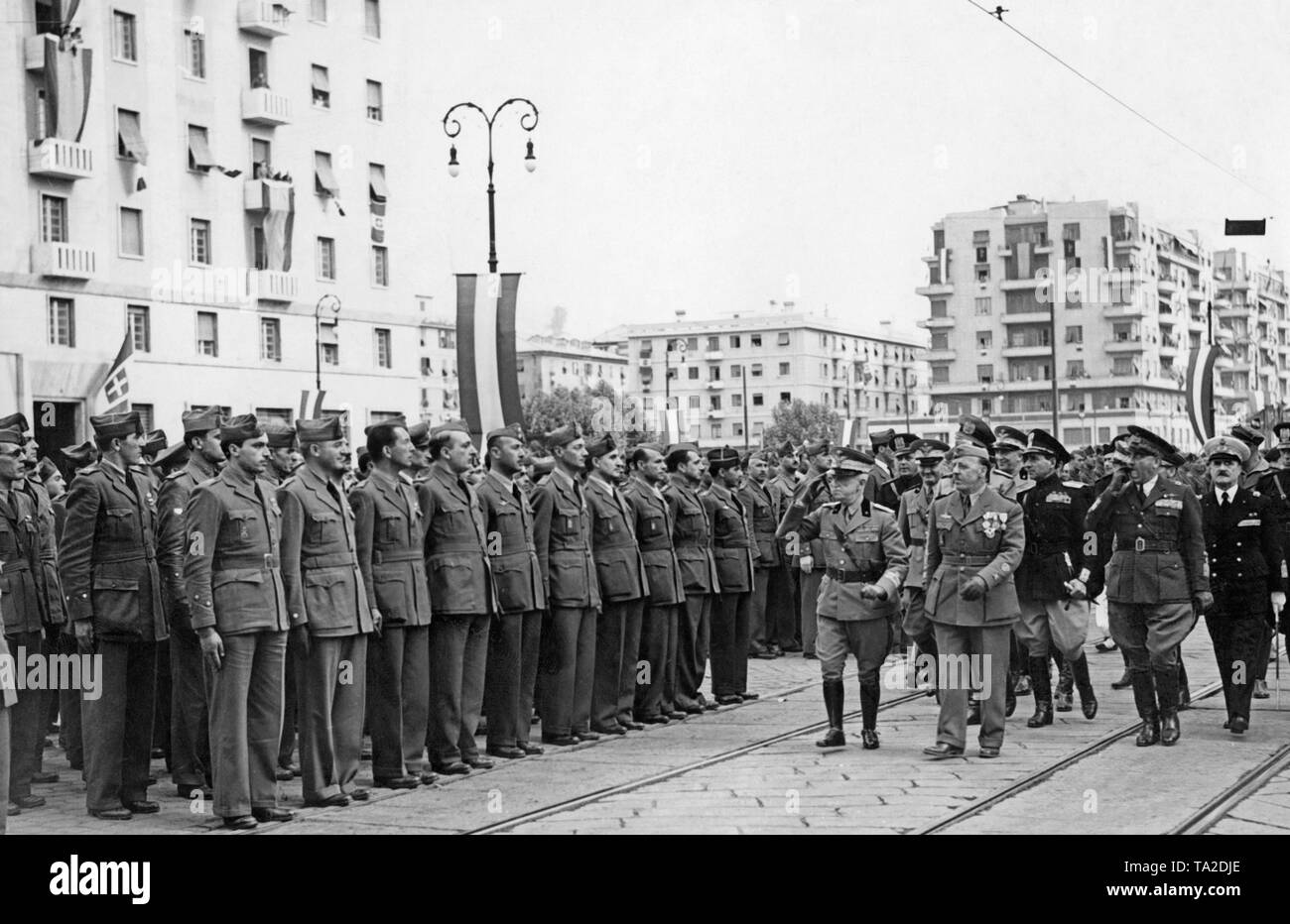 Italian soldiers returning to Italy, who fought as volunteers on the side of the Franco troops in the Spanish Civil War, are received by Victor Emanuel III of Italy (salutes with a peaked cap) and other high-ranking officers in the port of Genoa on June 15, 1939. Stock Photo