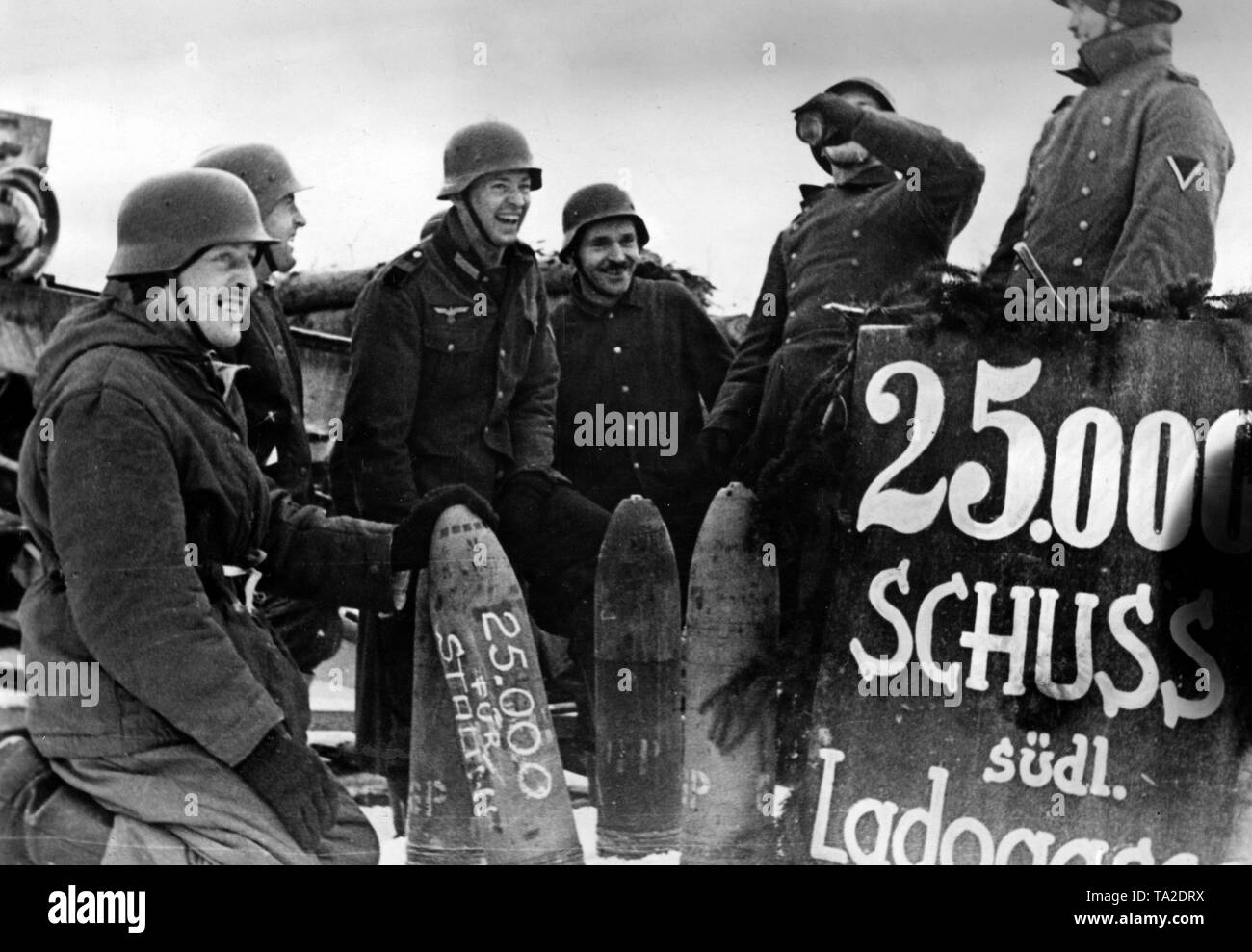 Gunners of an artillery battery celebrate their 25,000 shot. On the grenade next to its number, they have written a salute to Stalin. Photo of the Propaganda Company (PK): war correspondent Schuerer. Stock Photo