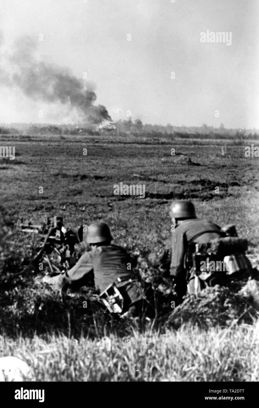 German infantrymen fighting the Soviet forces on the Donets front. They have entrenched themselves and fired with a machine gun 34th War correspondent: Ebert. Stock Photo