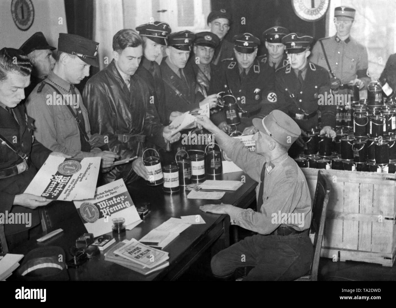 Members of SA and SS receive collecting boxes, with which they should carry out a 'Winterpfennig' collection for the Nazi Winter Relief. Stock Photo