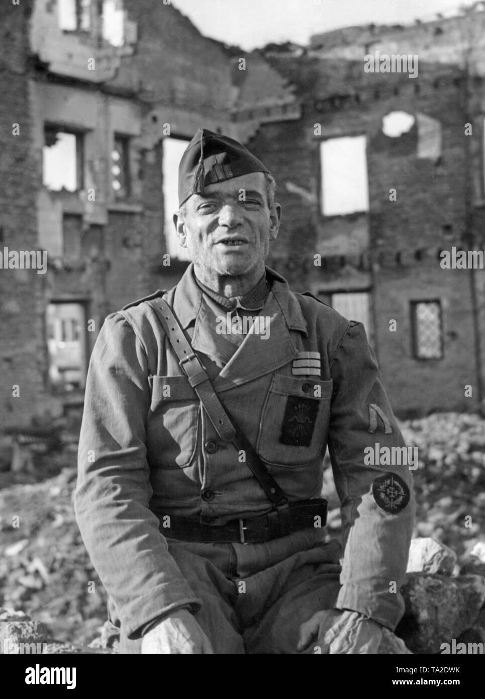 Portrait of a 60 year old sergeant of a volunteer corps fighting on the Spanish national side during the siege against the Republican troops. On the left forearm he wears the bravery badge of the defenders of Oviedo. In the background are ruins. Stock Photo