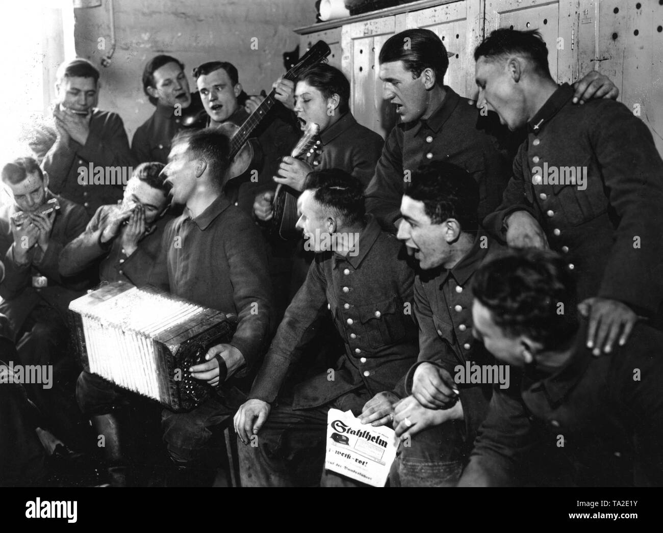 Men of the Volunteer Work Service of the Stahlhelm are singing and playing music after work done presumably for the new Reichsforschungsiedlung Haselhorst in Berlin. Stock Photo