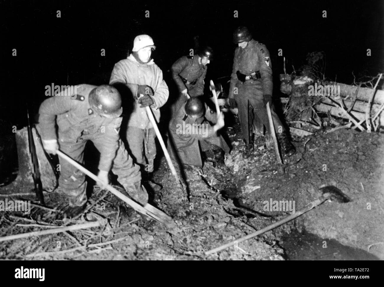 German soldiers are digging drains with buckets and hatchets for the communication trenches on the front. Due to its closeness to the front, work could only be done at night. Photo of the Propaganda Company (PK): war correspondent Hilkenbach. Stock Photo