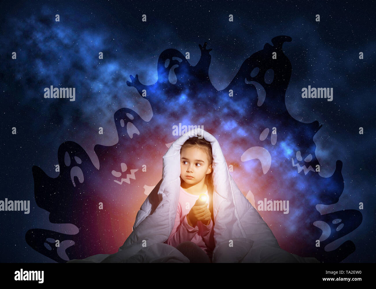 Scared girl with flashlight under blanket Stock Photo Alamy