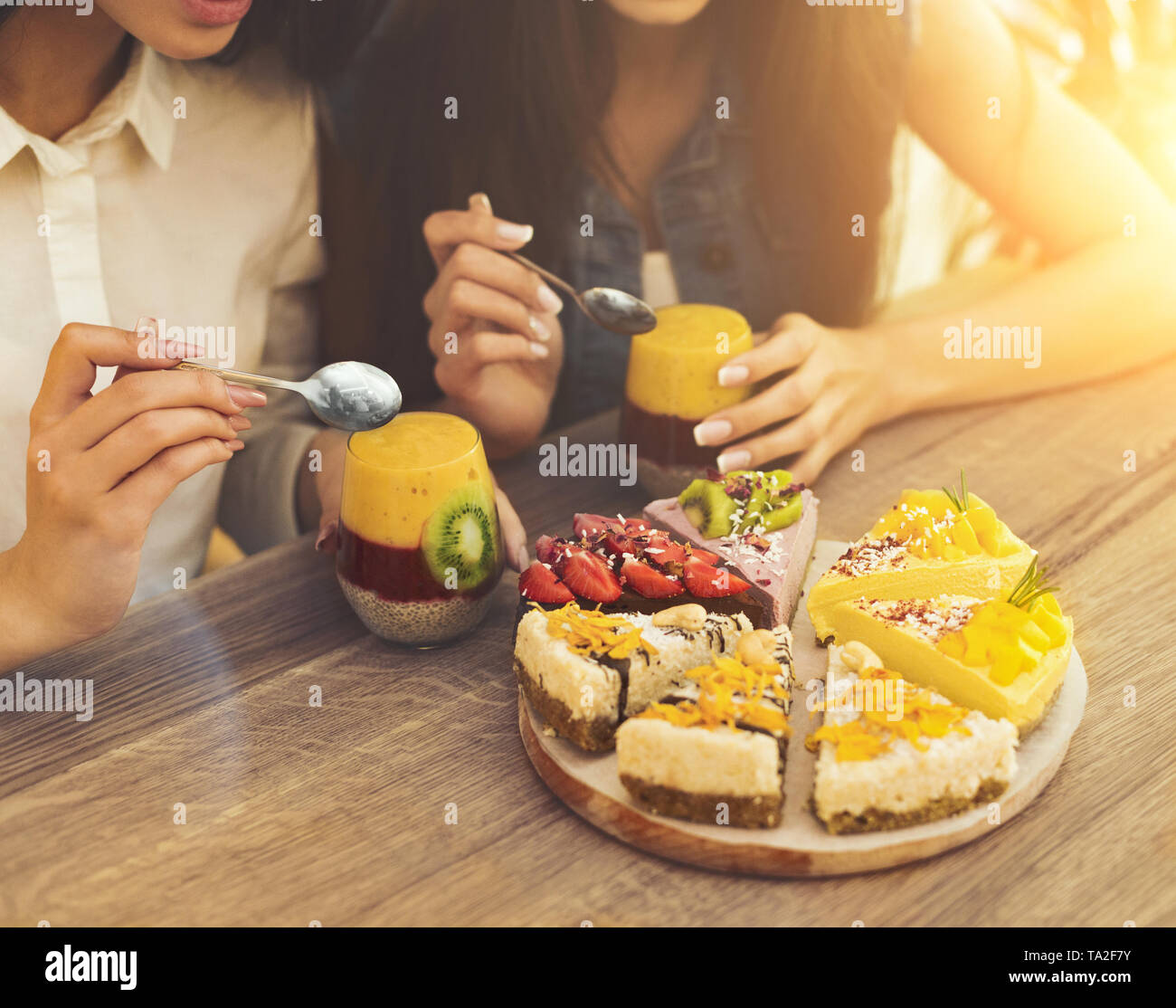 Two girls eating healthy cakes and smoothie Stock Photo Alamy