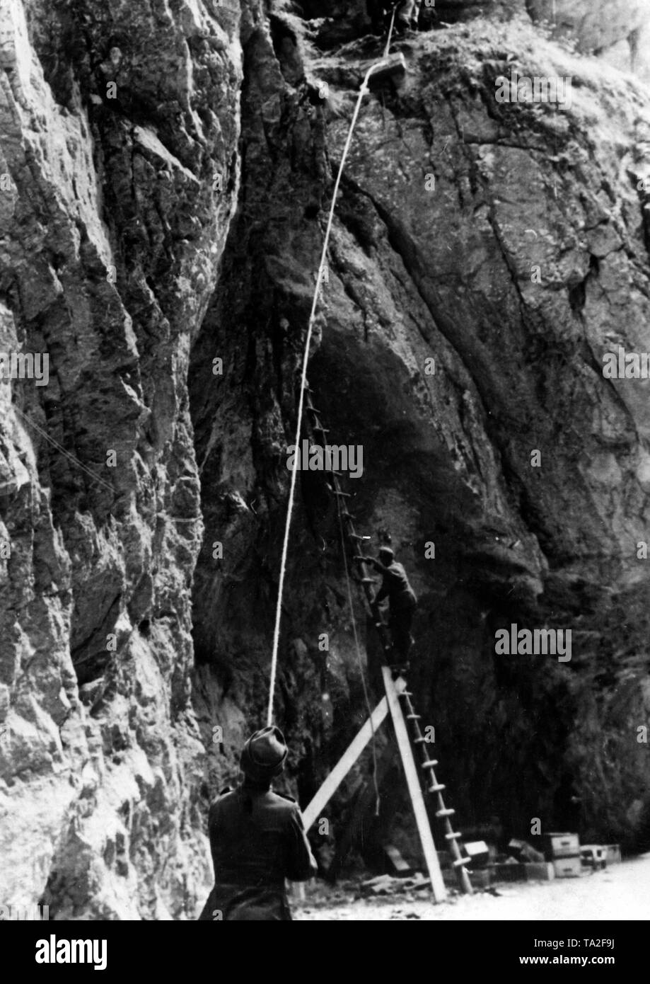 Pioneers of the Wehrmacht fix several tons of explosives with ladders and ropes in a rock wall in the Carpathians. Photo of the Propaganda Company (PK): war correspondent Mittelstaedt Stock Photo