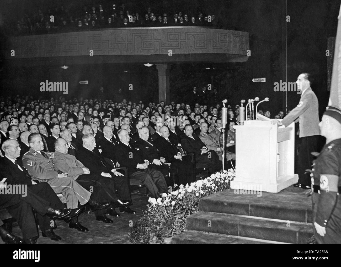 Reich Propaganda Minister Joseph Goebbels gives a speech at the company roll call in the UFA-Palast am Zoo on the occasion of the 25th anniversary of UFA. In the row of the guests of honor from left: Secretary of State Leopold Gutterer, Reich Minister of Economics Walther, Privy Councilor dr. Alfred Hugenberg, Director-General Ludwig Klitzsch, Reich Organization Director Robert Ley, Mayor Dr. Max Winkler, State Actor Veit Harlan, Gauleiter and Deputy State Councilor Artur Goerlitzer. Stock Photo