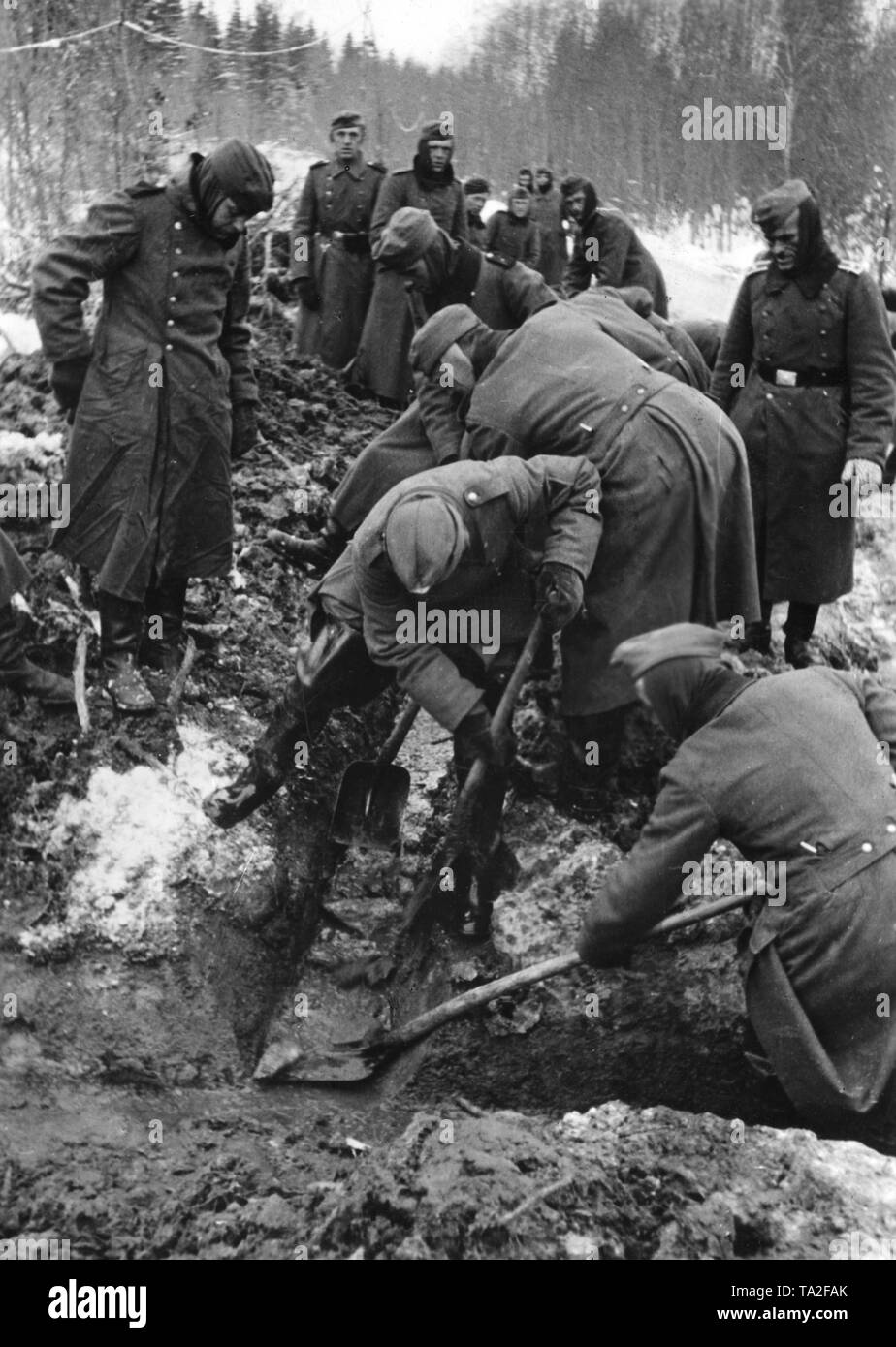 Workers of the Todt Organization are busy with provisions against flooding at Koper on the Eastern Front in the Soviet Union. Wellington boots protect the soldiers of the construction battalion from the cold and wet weather. War reporter: Schmidt. Stock Photo