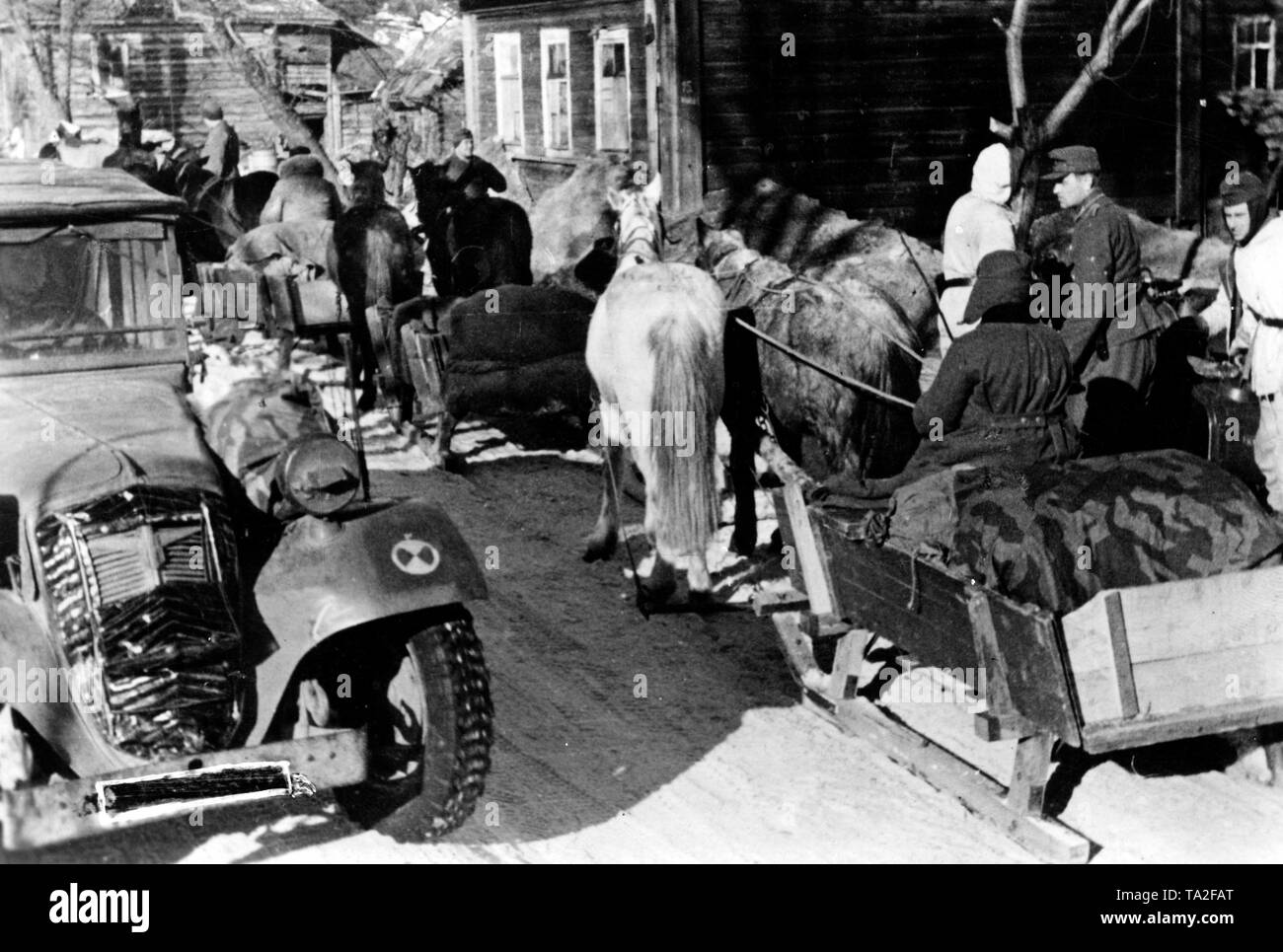 German soldiers are evacuating the Demyansk Pocket on horse-drawn sleighs. Here they cross a village at the bridgehead of the salient. Photo of the Propaganda Company (PK): war correspondent Beissel. Stock Photo