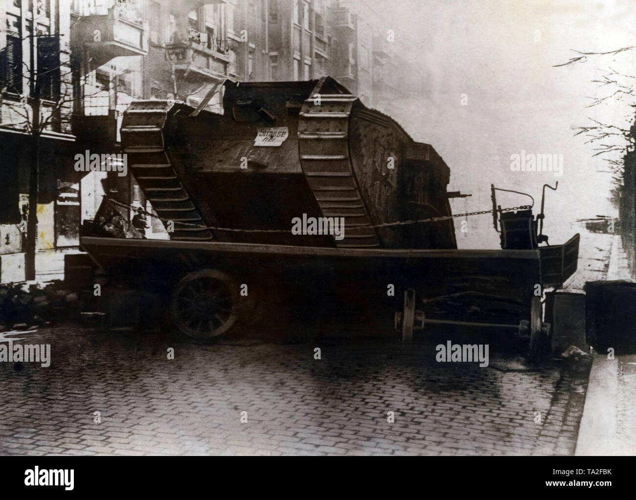 In the course of the Berlin Maerzkaempfe (March fights), a Mark IV tank of the government forces breaks through a blockade of insurgents. The tank with the name 'Hanni' was captured by the British in the First World War. It is a female version of the model with machine guns. Stock Photo