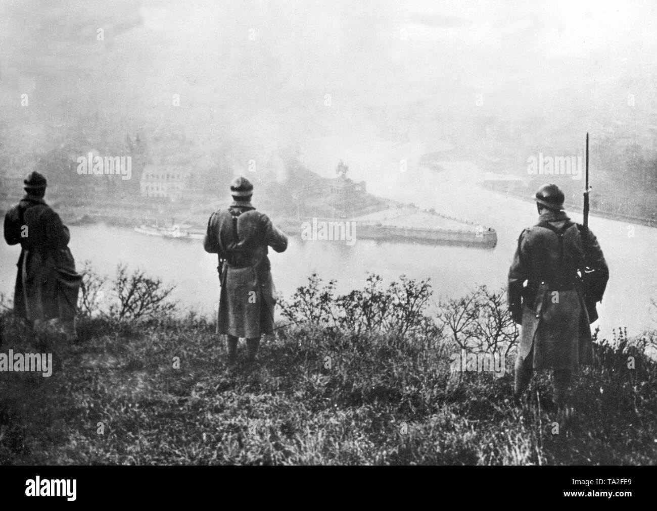 Three French soldiers look at the mouth of the Moselle in the Rhine
