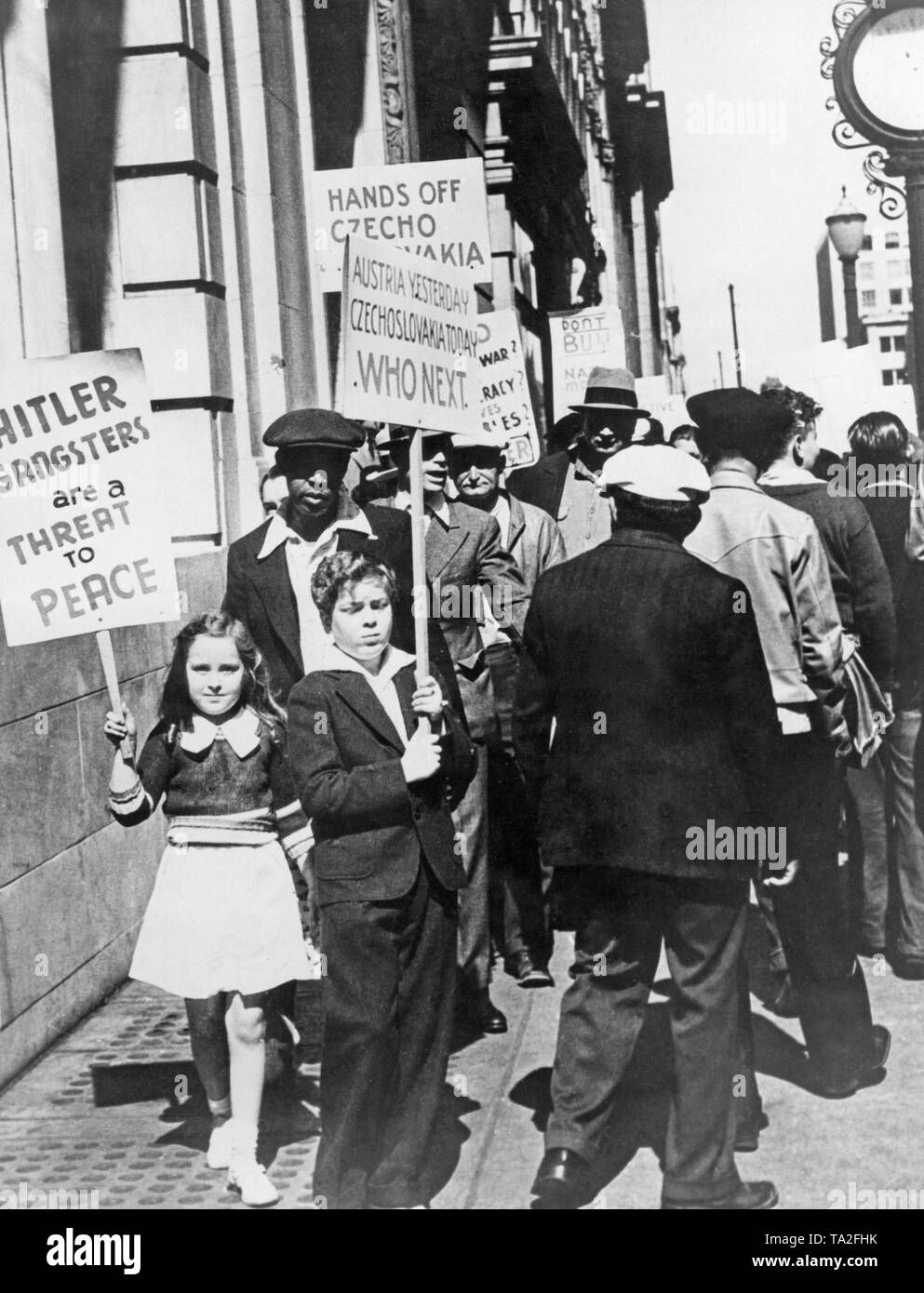Children carry signs at an anti-Nazi demonstration in San Francisco. On the signs: 'Hitler's gangsters are a threat to peace,' 'Austria yesterday Czechoslovakia today who next.' and 'Hands off Czecho-Slovakia'. In the Sudetenland crisis, Hitler provoked an international conflict to annex the Sudetenland to the German Reich. Stock Photo