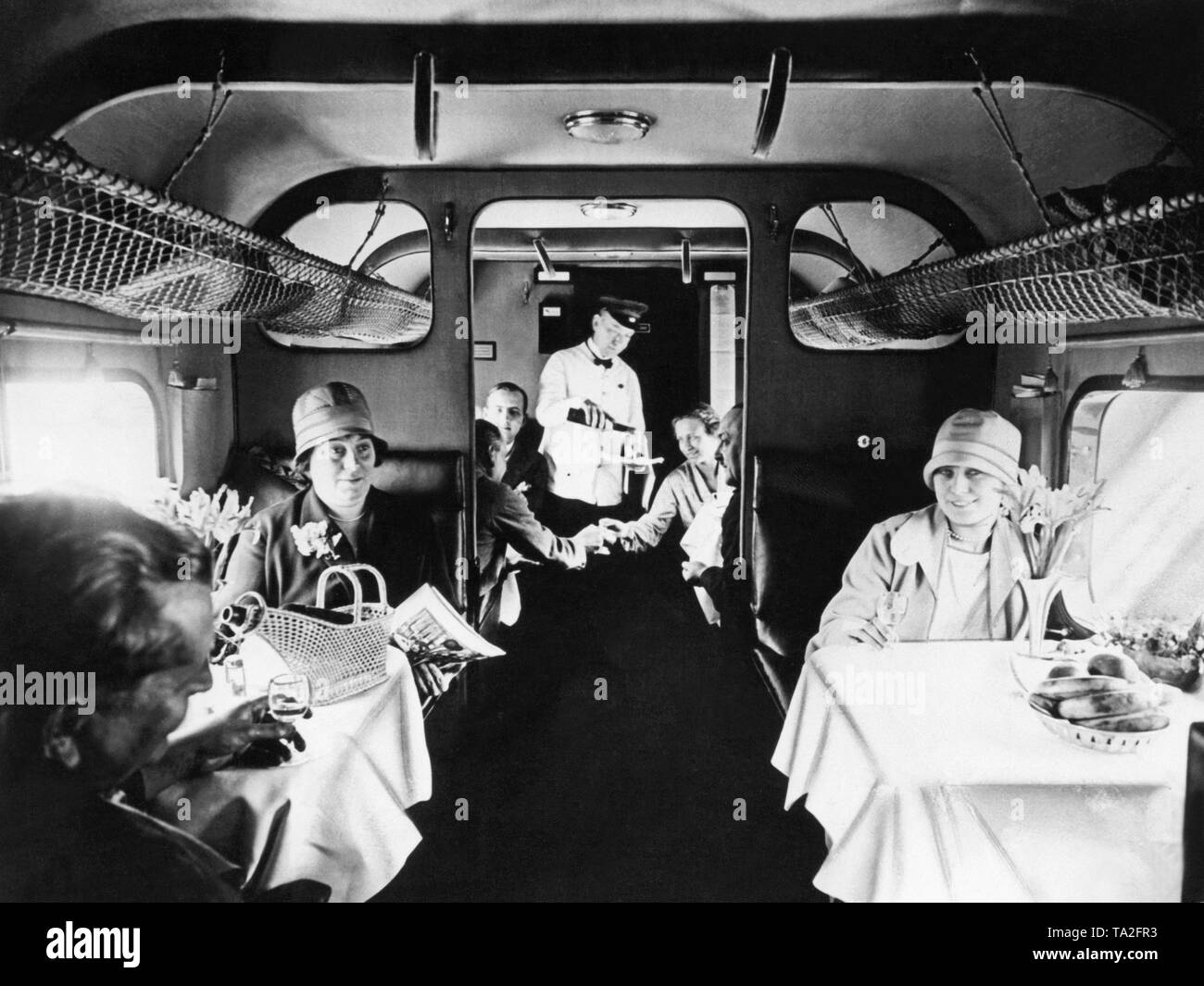 Flight attendant and passengers in the cabin of a Junkers G 31 of the Flight attendant and passengers in the cabin of a Junkers G 31 of the