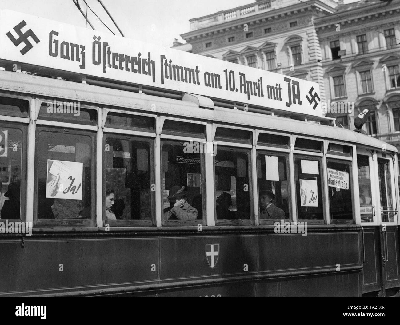 Billboard for the referendum on the annexation of Austria to the German Reich on a Viennese tram. After the invasion of the German troops in Austria a referendum is about to be held on the annexation of Austria to the German Reich. On the board is written: 'All of Austria votes with YES on the 10th of April'. Stock Photo