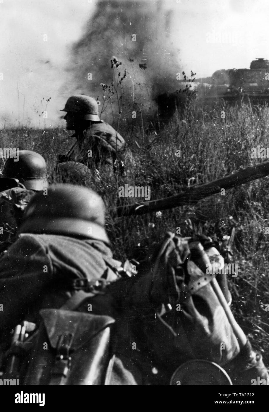 In a battle field in the region of Oryol (Orel), a grenade of Soviet anti-tank guns strikes right in front of a German Panzer IV and infantrymen. Photo of the Propaganda Company (PK): war correspondent Kraayvanger. Stock Photo