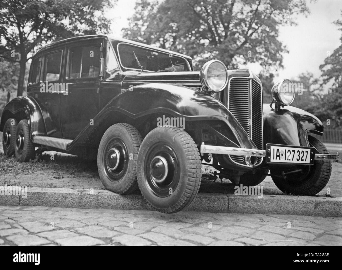 A car with an extended wheelbase, four axles and eight wheels when driving over a curbside. The designer of the car is the Berlin engineer Rimmek. Stock Photo