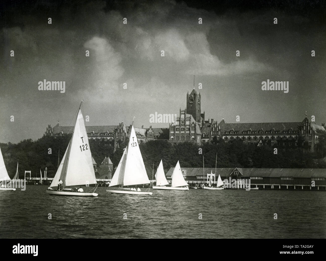 The Naval Academy in Muerwik in Flensburg, in the foreground are some sailboats training on the water. It is a picture from the Nazi propaganda film 'Comrades at Sea' from 1938. Stock Photo