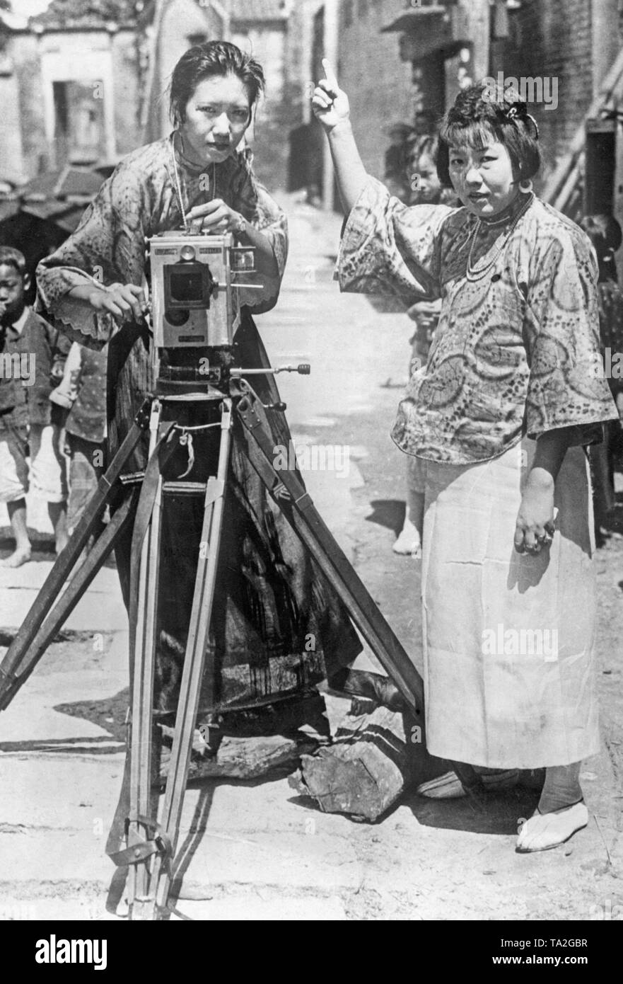 This photograph shows two Chinese film operators documenting the occupation of Canton by Red soldiers and workers' brigades. Stock Photo