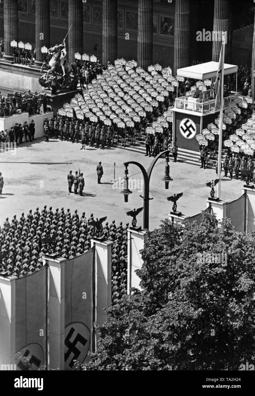 Flag command of the Condor Legion (with the troop banner, Spanish: bandera) standing in front of the lectern in the Berlin Lustgarten during the speech of Adolf Hitler (under canopy with swastika). In front of it stands the commander Major General Wolfram Freiherr von Richthofen. Behind them soldiers of a guard regiment, Hitler Youth members holding the signs with the names of the fallen and the facade of the Altes Museum. Stock Photo