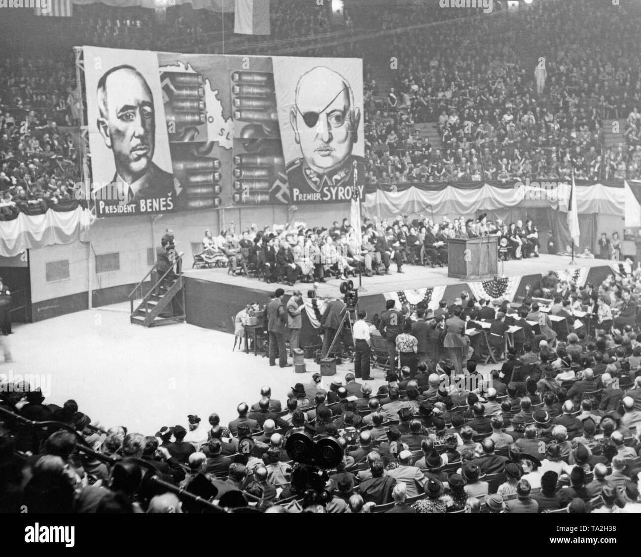 The Committee for the Salvation of Czechoslovakia meets in Madison Square Garden, New York. Among others, Thomas Mann and Dorothy Thompson give speeches at the convention. In the background, posters with the images of President Benes and Prime Minister Syrovy. Adolf Hitler provoked the Sudetenland crisis to annex the Sudetenland to the German Reich. Stock Photo