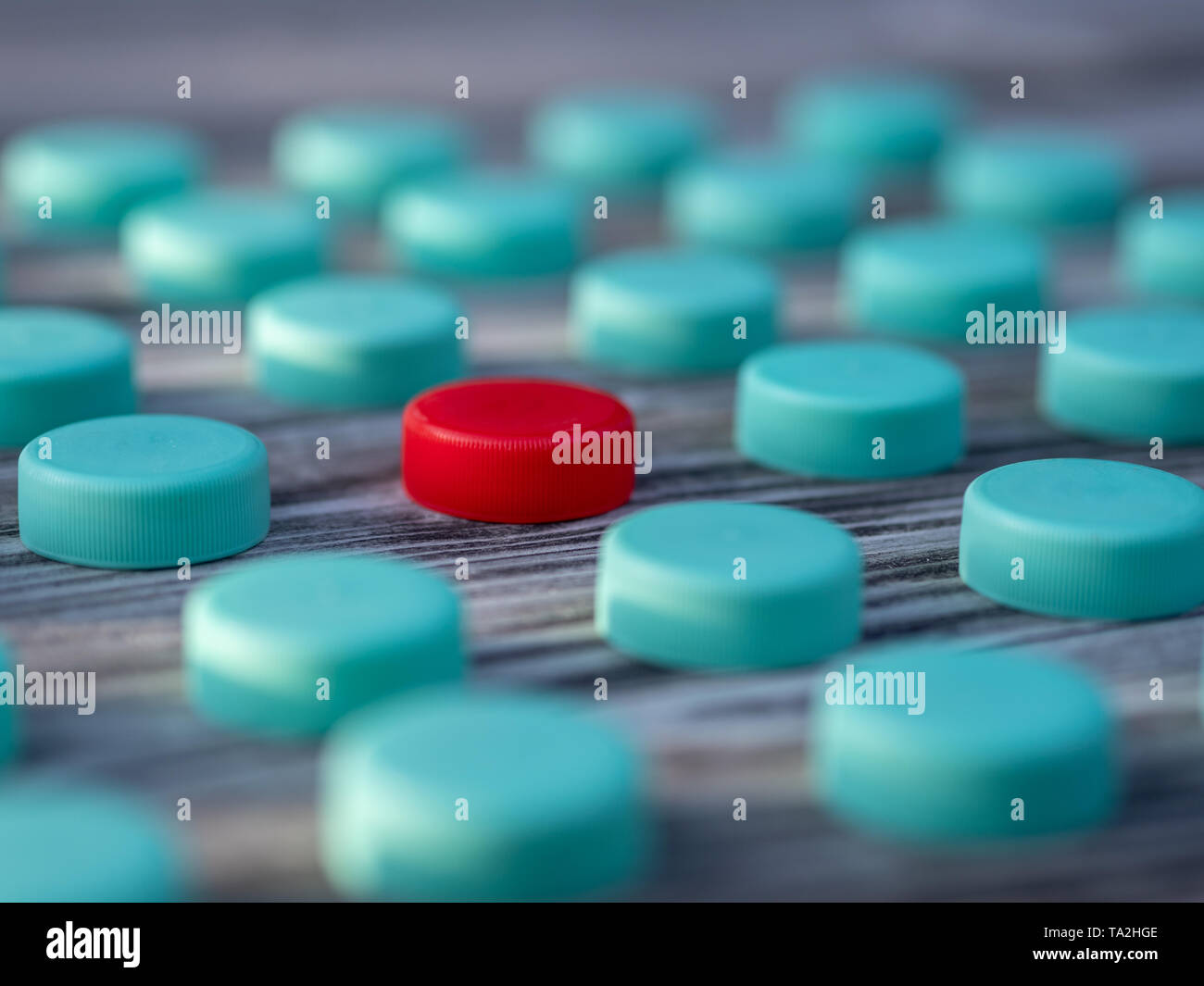 Image of different colored plastic caps on wooden background Stock Photo