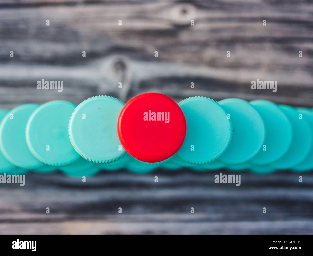 Image of different colored plastic caps on wooden background Stock Photo