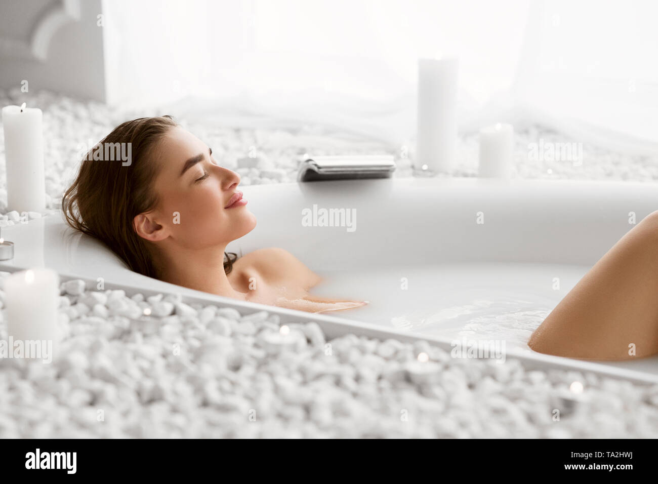 Beautiful Woman Relaxing In Milky Bathtub With Closed Eyes Stock Photo