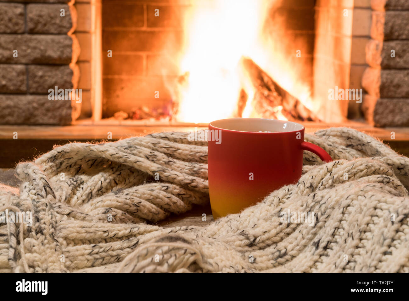 https://c8.alamy.com/comp/TA2J7Y/big-mug-with-tea-and-warm-wool-scarf-near-cozy-fireplace-in-country-house-winter-vacation-TA2J7Y.jpg