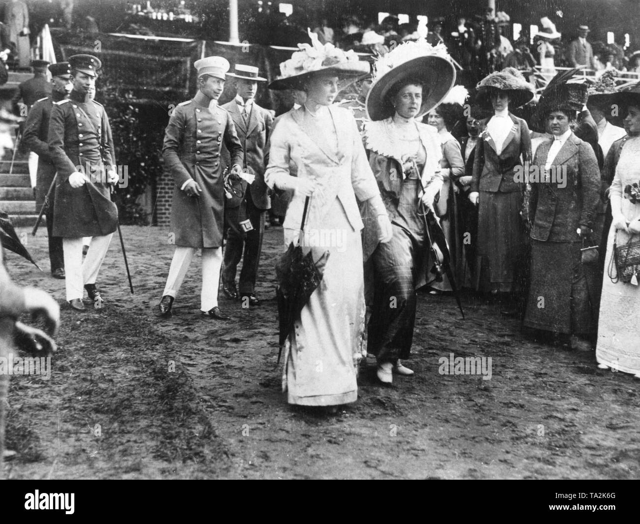 Crown Prince Wilhelm (3rd from the left with binoculars in hand) visits a racecourse in Ruhleben with his wife Cecilie (front left) and his sister Sophie Charlotte of Oldenburg (front right). Stock Photo