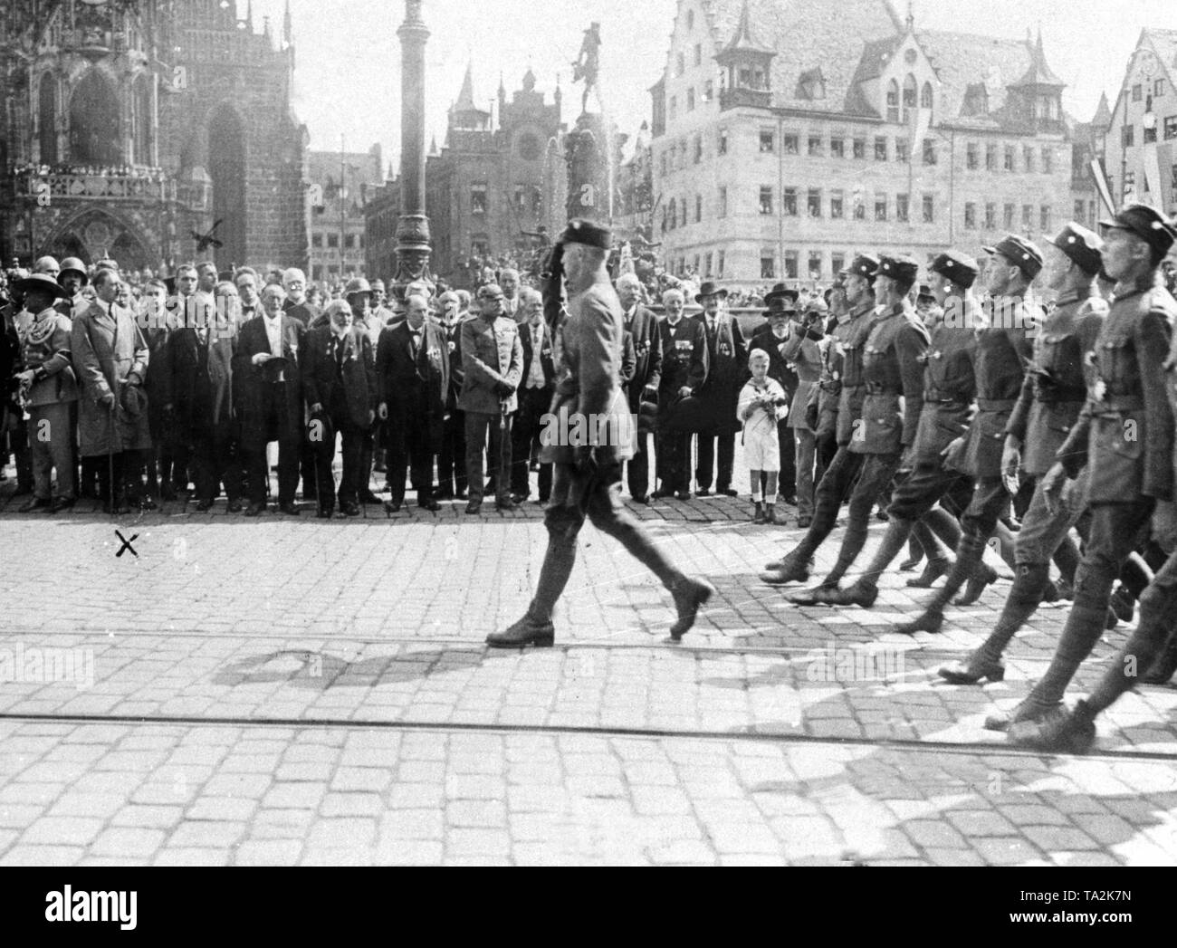 Adolf Hitler (3rd from left) and right behind him presumably Ernst Roehm watch the march past of an SA unit in front of the Frauenkirche in Nuremberg. Stock Photo