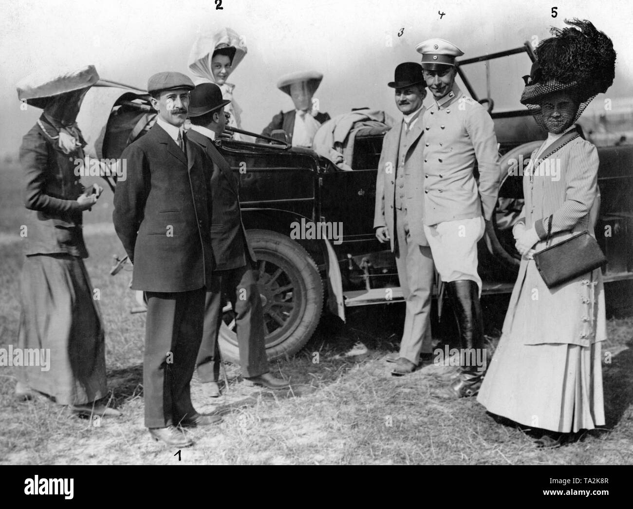 Crown Prince Wilhelm (4) arrived, together with his wife Crown Princess Cecilie of Prussia (2), born Duchess of Mecklenburg, to the airfield Tempelhof Field to follow the flight demonstration of Orville Wright (1). Here, the Crown Prince Couple with his entourage and their siblings Wright. From 1-5: Orville Wright (1), Crown Princess Cecilie of Prussia (2), Captain Hildebrandt (3), Crown Prince Wilhelm of Prussia (4), Miss Catherine Wright (5). Stock Photo