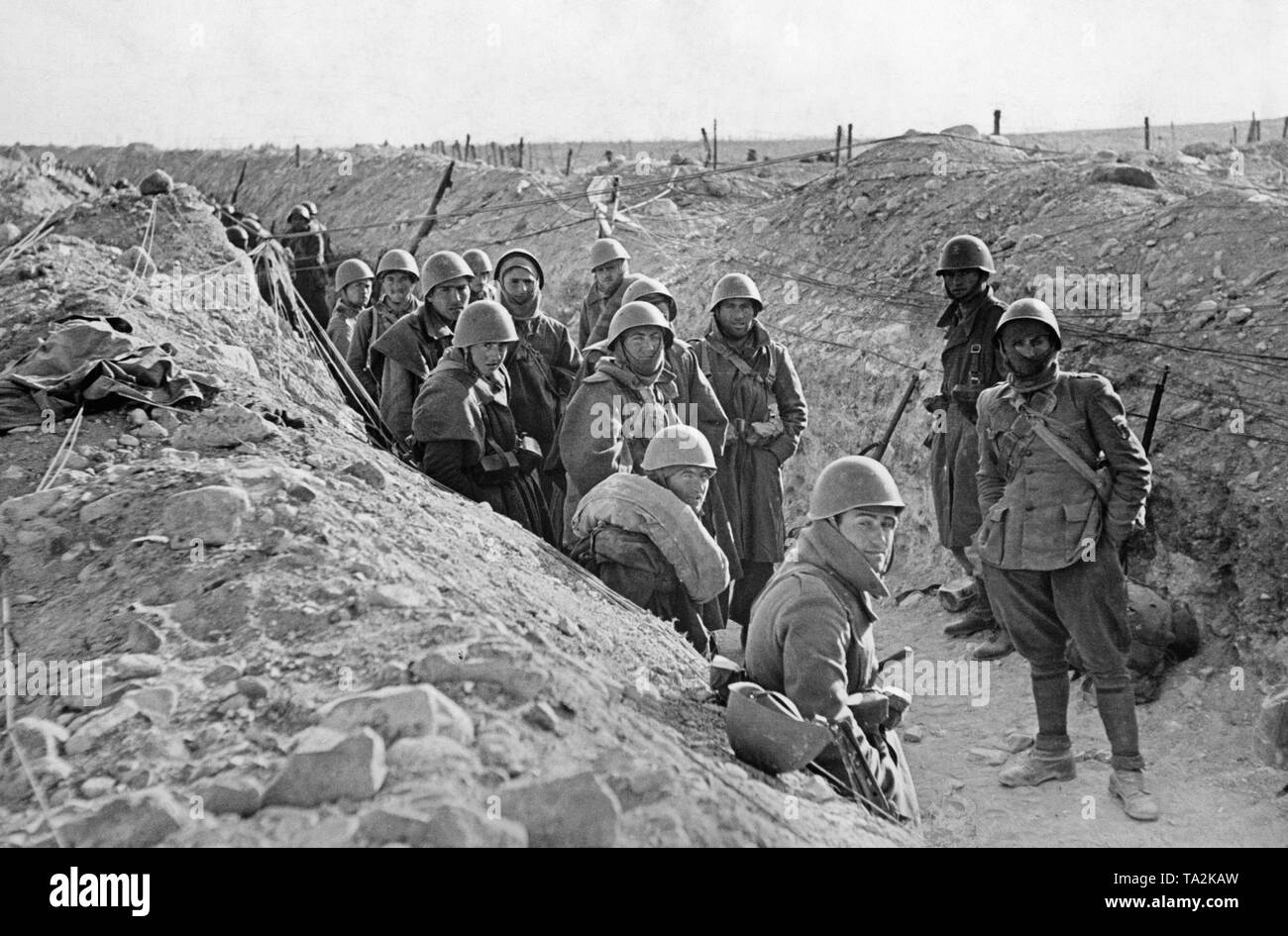 Photo of a group of Italian legionaries in winter clothes and steel helmet in a trench at Toledo on March 28, 1939. At the end of March, the last battles of the Spanish Civil War took place, which ended with the victory of the Franco troops on April 1, 1939. Stock Photo