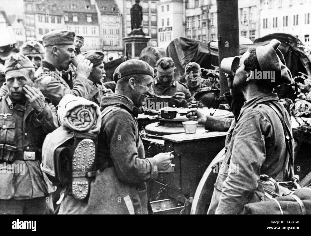 Former prisoners Alsatians, who have already been released from captivity, are fed together with German soldiers at a German field kitchen in a city in Alsace. Stock Photo
