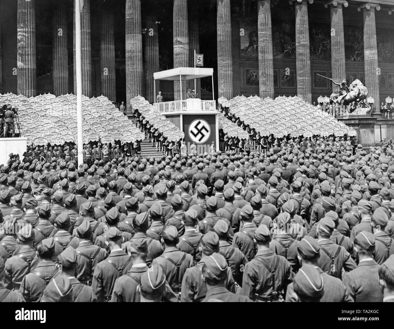 Adolf Hitler during a speech under a canopy with swastika during the state ceremony for the Condor Legion in the Lustgarten on the Museum Island on June 6, 1939. Next to him is Hermann Goering. In the foreground stand the lined up legionaries. To the right and left of the lectern are Hitler Youth members with signs bearing the names of fallen Spanienkaempfer (people who who fought for the Left in Spain). On the far left are film cameras. Adolf Hitler during a speech under a canopy with swastika at the state ceremony for the Condor Legion in the Lustgarten on the Museum Island on June 6, 1939. Stock Photo