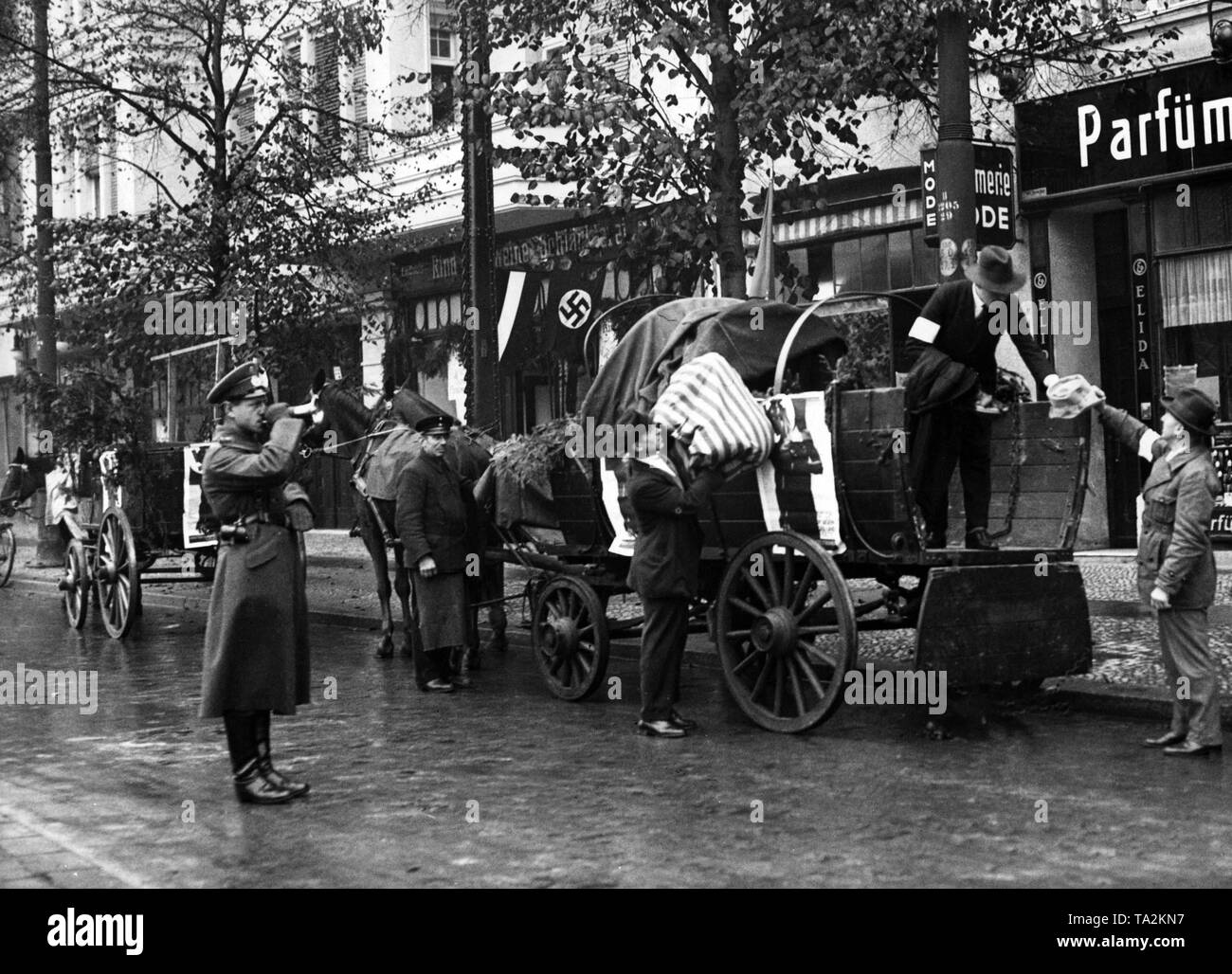 Raising campaign for the Nazi Winter Relief with trumpeter and horse-drawn carts of the Wehrmacht in Berlin-Charlottenburg. Stock Photo