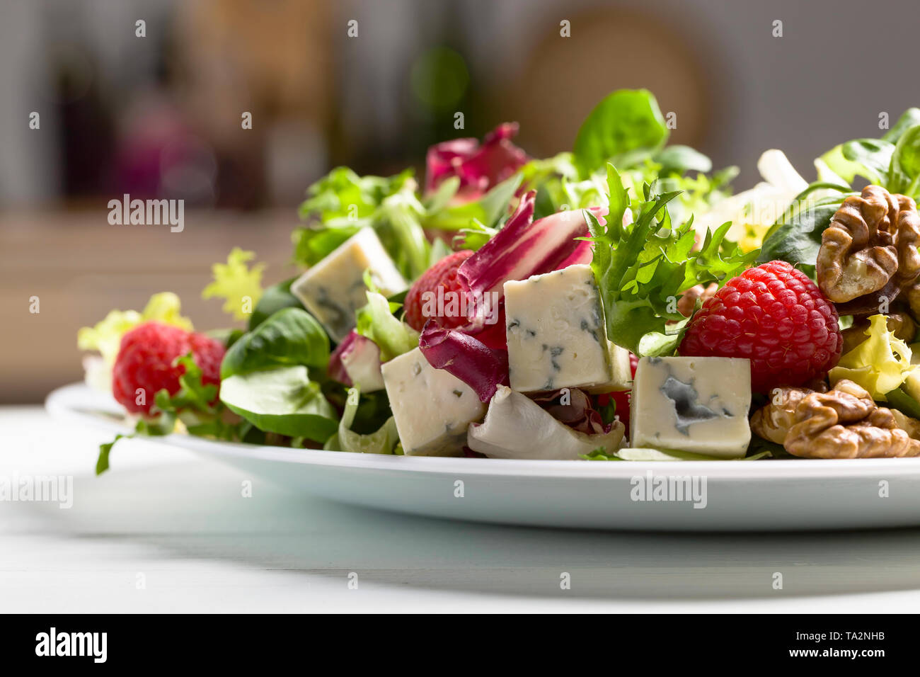 Healthy green salad with blue cheese, raspberry and walnuts Stock Photo