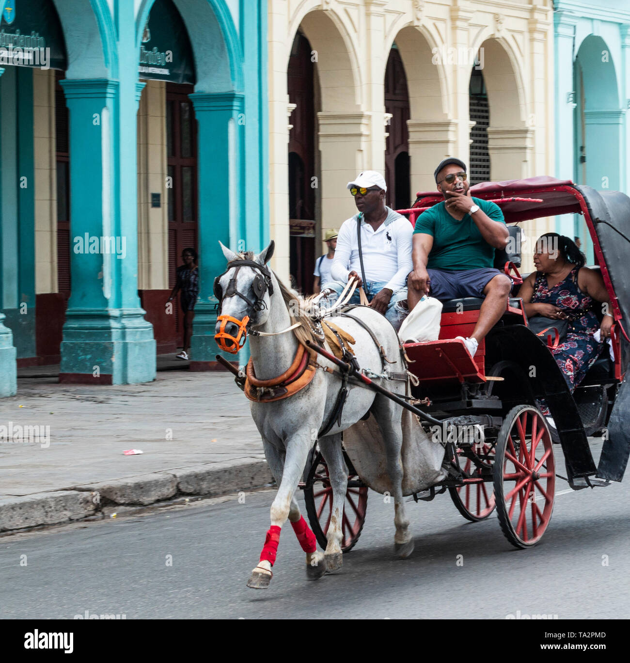 Havana, Cuba - 25 July 2018: A family of tourists taking a ride on a horse and buggy through the colorful streets of Old Havana Cuba. Stock Photo