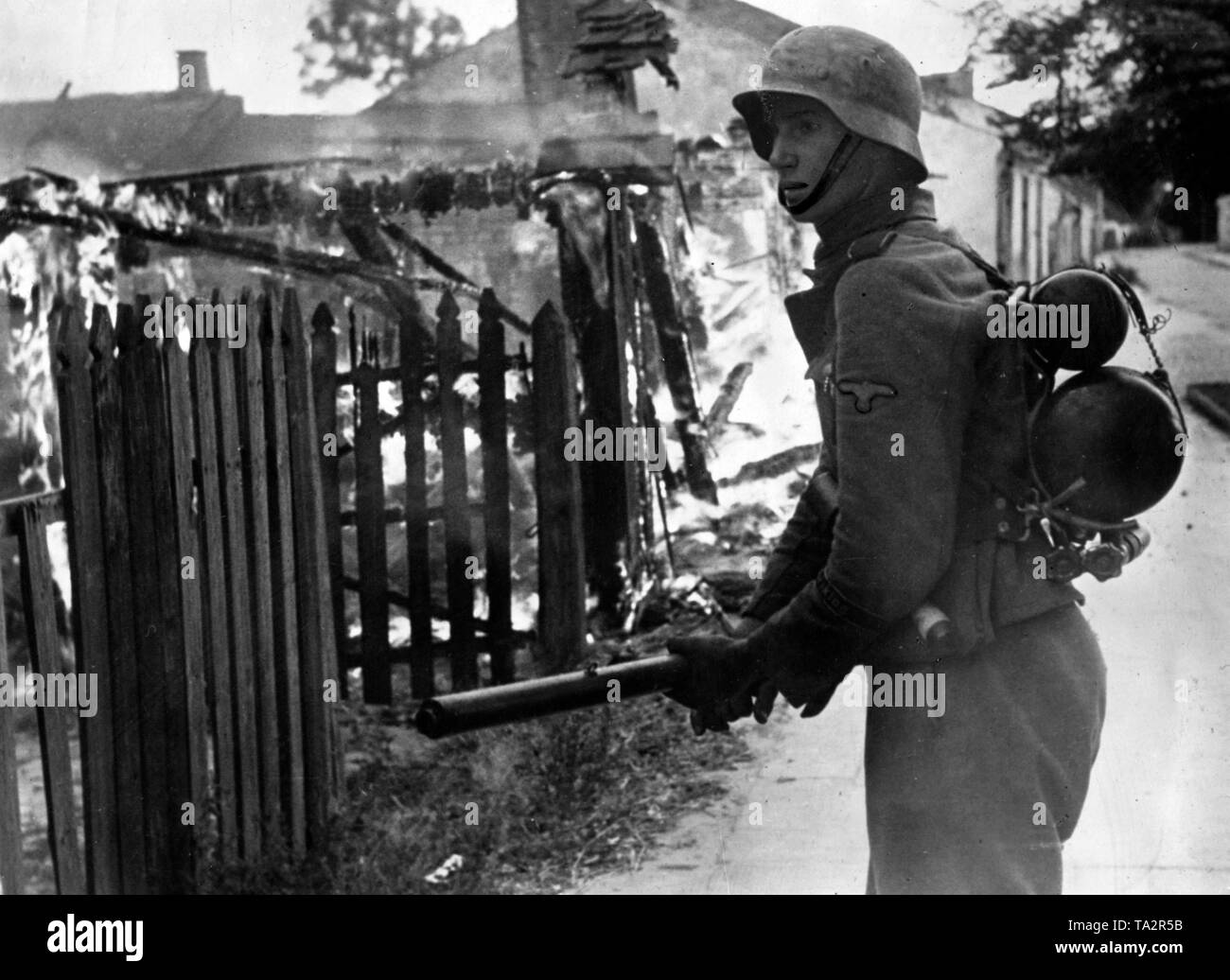 German soldier with a flamethrower 41 is burning down a house at