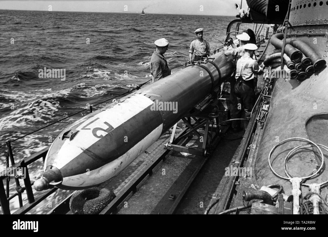 The picture shows members of the crew of a German destroyer of the Kriegsmarine (Navy) repairing a practice torpedo as it was used at that time by the Kriegsmarine during maneuvers and target practice. Stock Photo