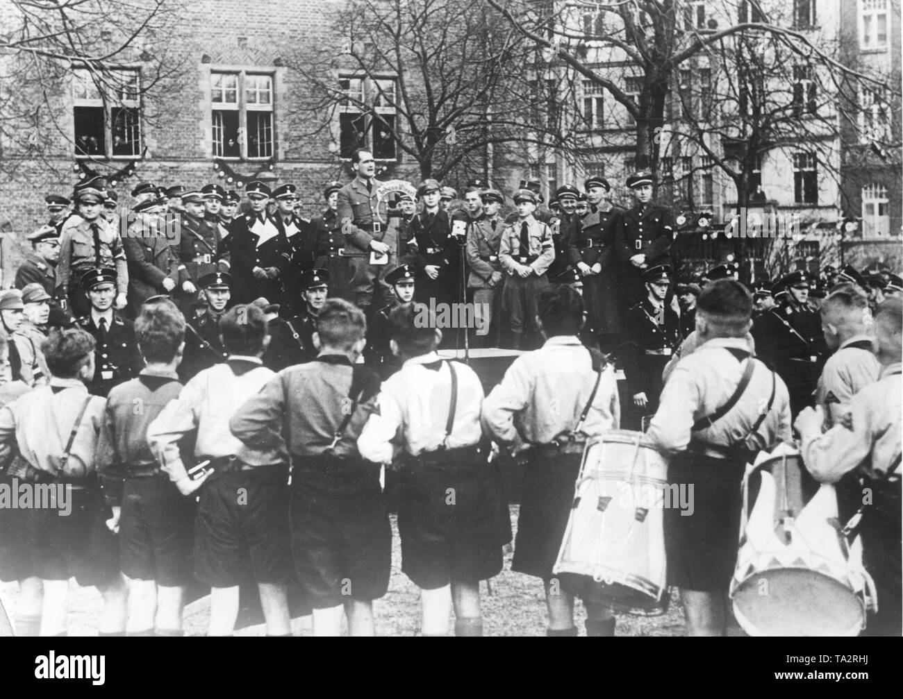 On the occasion of the elections in Gdansk, Hitler's deputy Rudolf Hess gives a speech in front of the Hitler Youth of Gdansk. On the tribune, SS members stand guard. Stock Photo